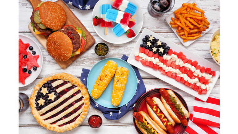 Fourth of July, American food. Above view table scene on white wood.