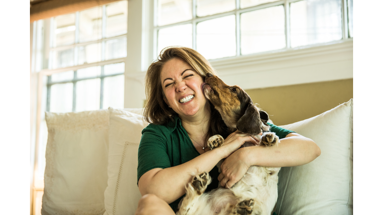 Woman cuddling in bed with dog