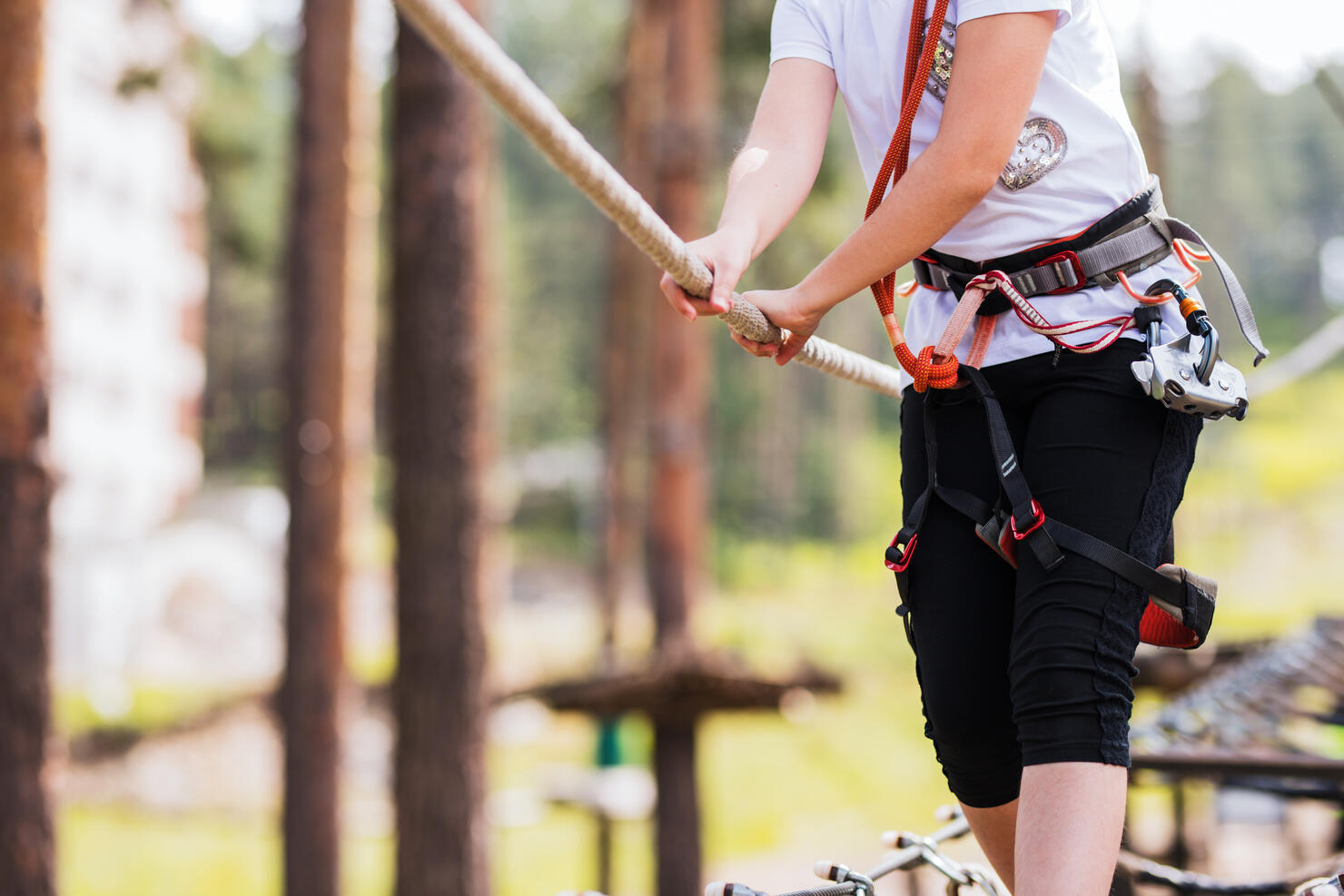 Close up of a child wearing safety equipment when holding onto a rope