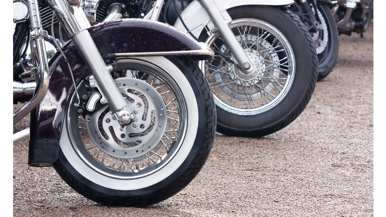 Wheels of motorbikes standing in a row close up