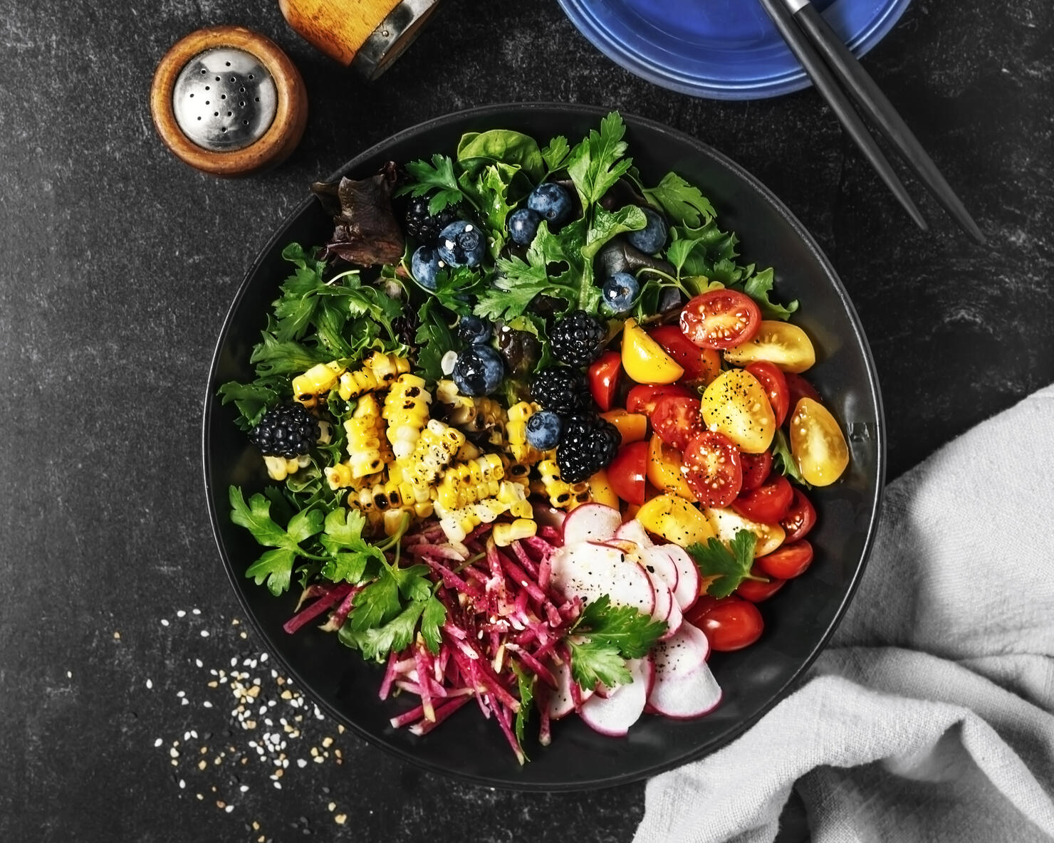 Bowl of fresh salad on black background