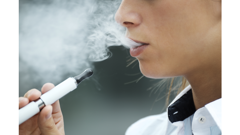 closeup of woman smoking electronic cigarette outdoor