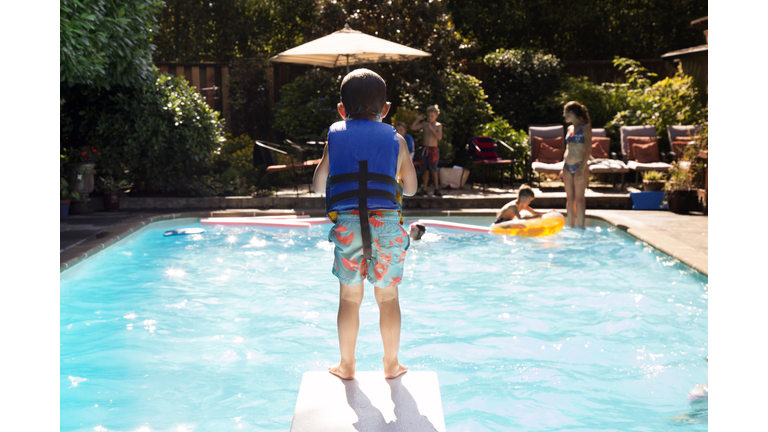Boy standing on diving board