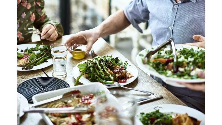 Cropped view of table laid with crockery and fresh homemade vegetarian food