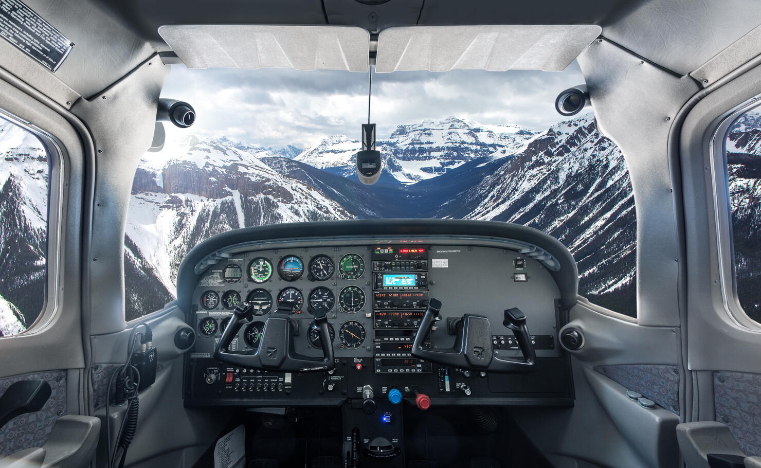 View past plane cockpit to snowy mountains