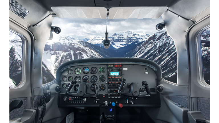 View past plane cockpit to snowy mountains