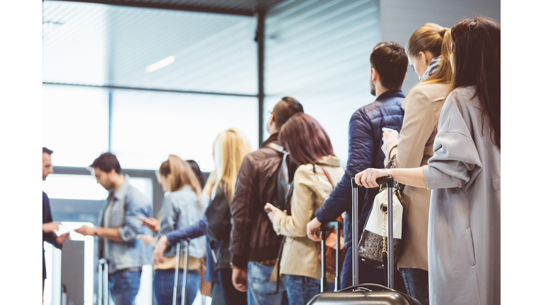 Group of people standing in queue at boarding gate