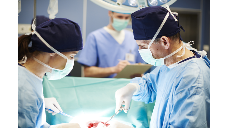 Busy surgeons over the operating table