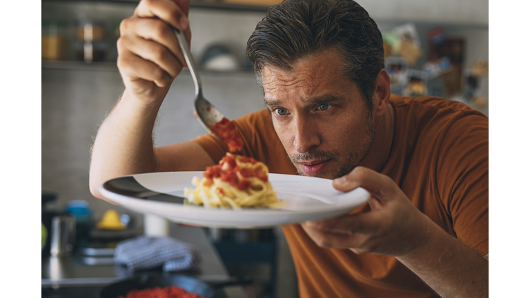 Handsome Young Caucasian Man Making Classic Tagliatelle in a Kitchen