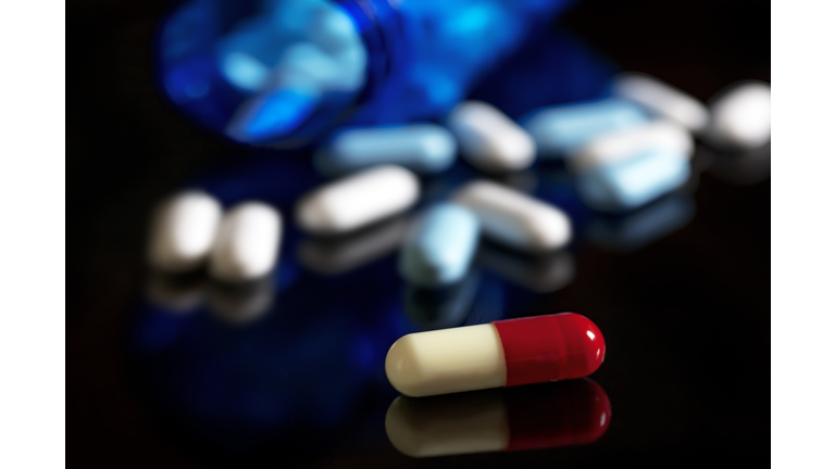 Spilled capsules and pills On black background. Medical concept