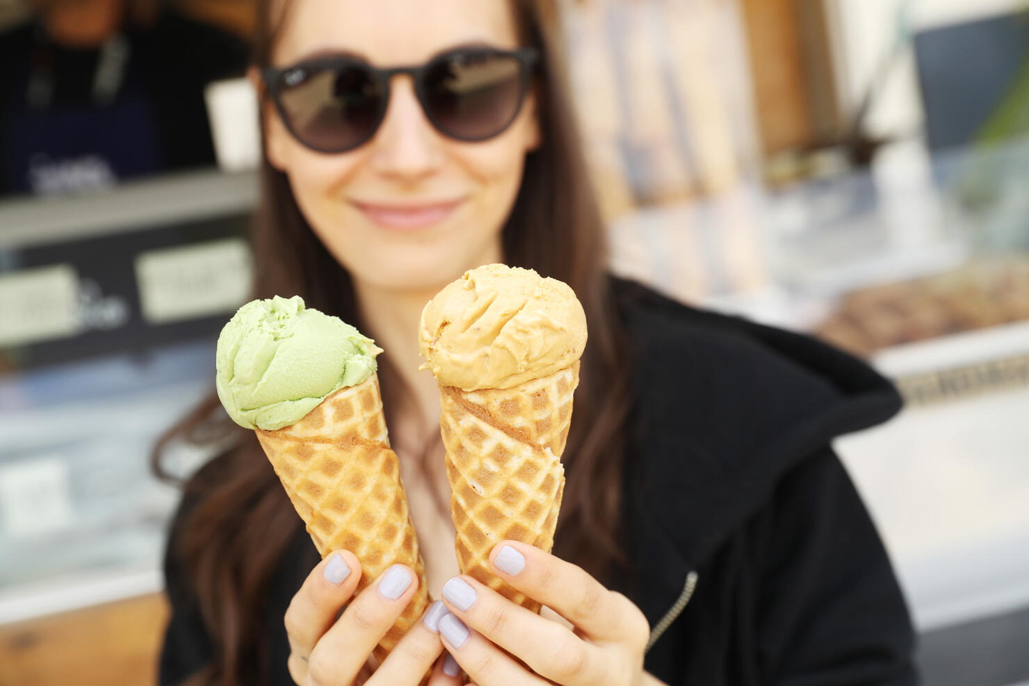 A woman holding two ice cream cones. 