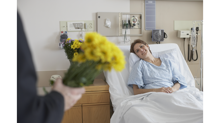 Hispanic woman getting flowers in hospital