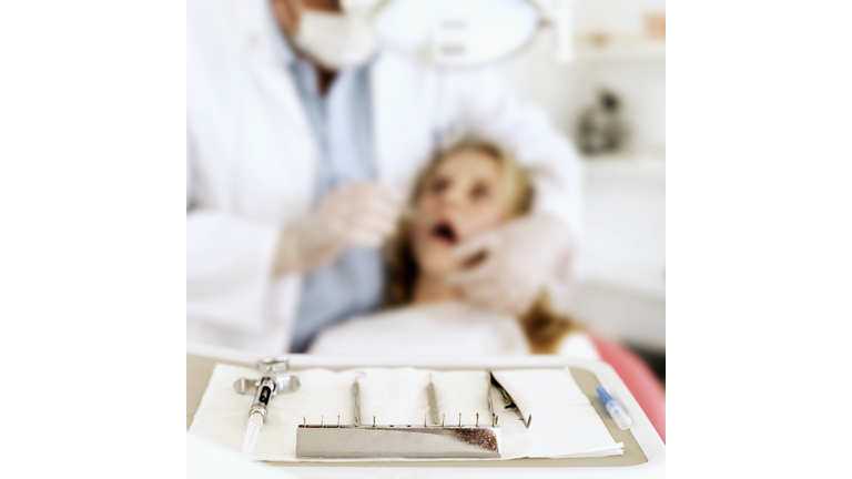 close-up of a dental equipment and dentist treating patient in background