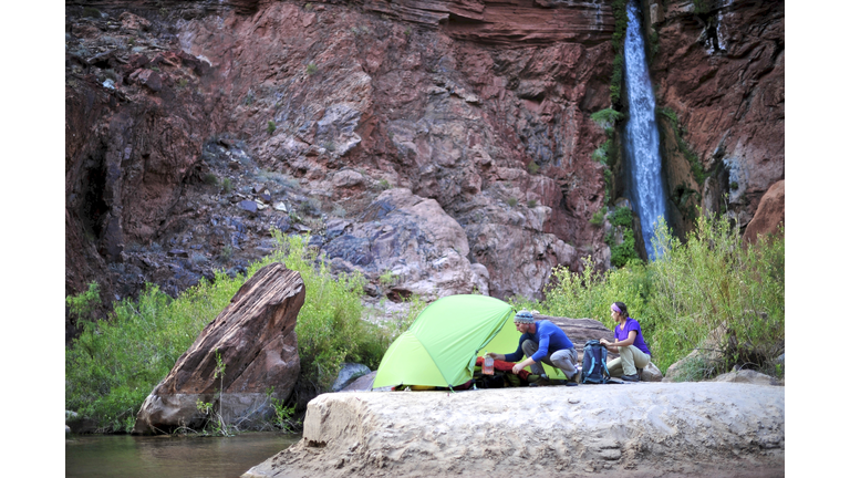 Hikers setup camp on a beach along the Colorado River near the plumeting 180-foot Deer Creek Falls in the Grand Canyon outside of Fredonia, Arizona November 2011.