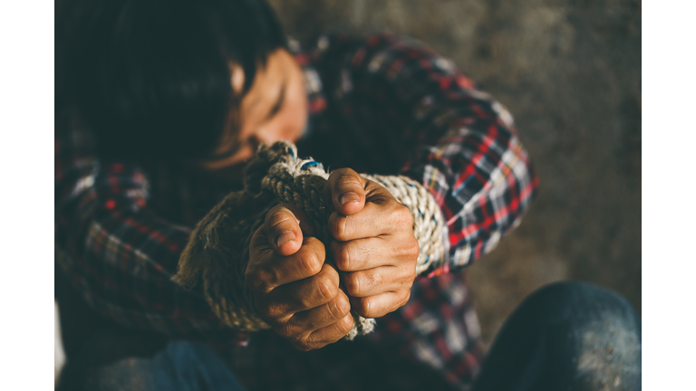 Helpless young man hands tied with rope, Missing kidnapped, Hostage, human trafficking and violence concept