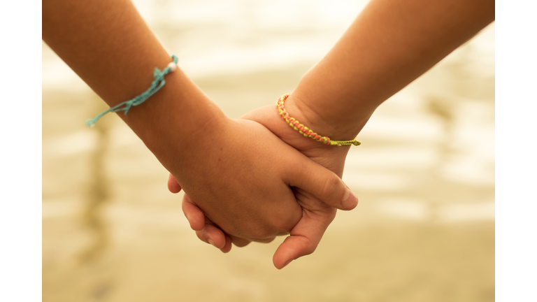 Happy children friends hold hands in summertime