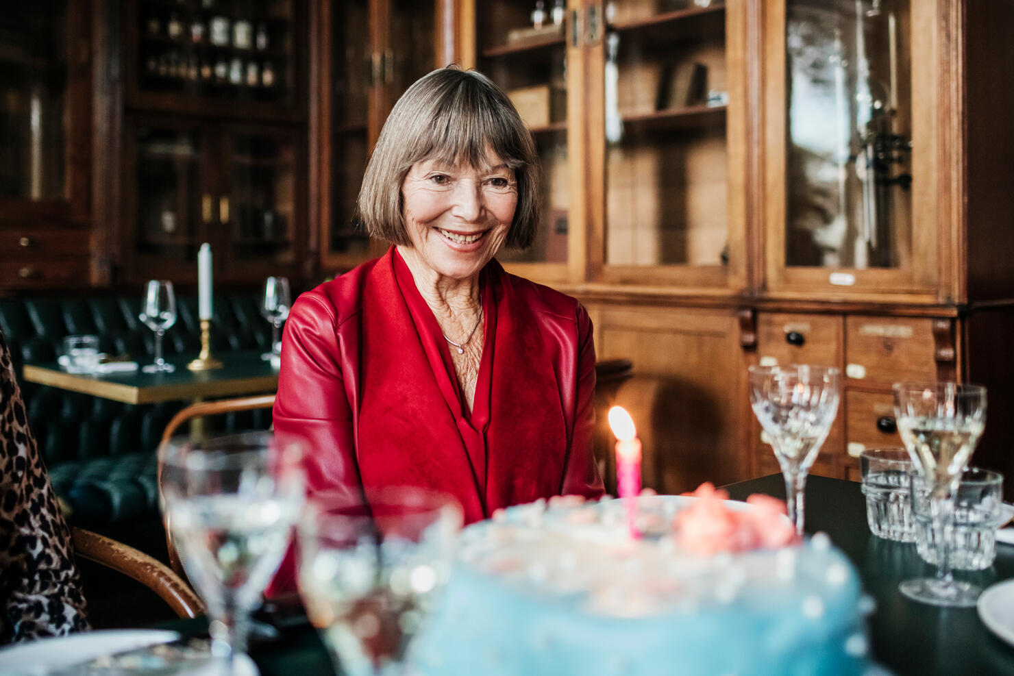 Mature Woman Smiling While Looking At Birthday Cake