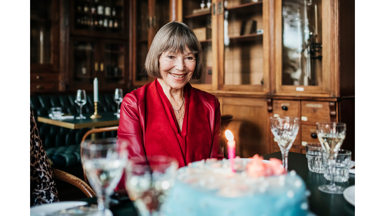 Mature Woman Smiling While Looking At Birthday Cake