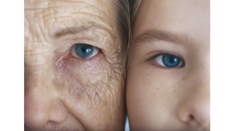 Girl and grandmother, cheek to cheek, close-up, partial view