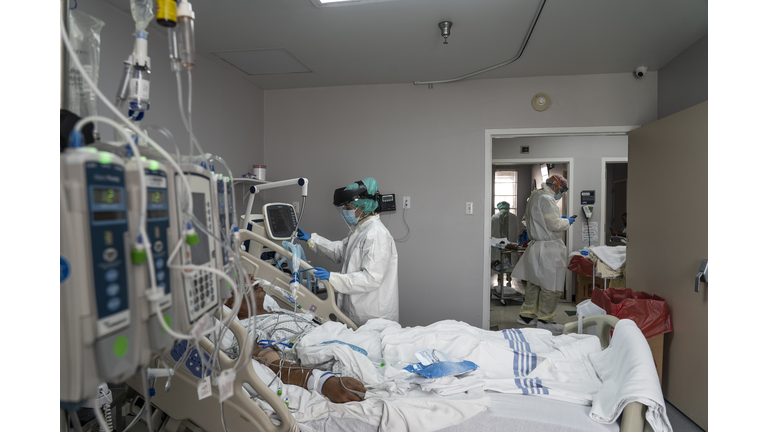  A member of the medical staff wearing full PPE treats a patient in the Covid-19 intensive care unit at the United Memorial Medical Cente in Houston, Texas. 