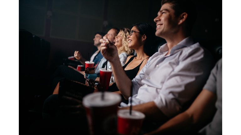 Group of people in theater with popcorn and drinks