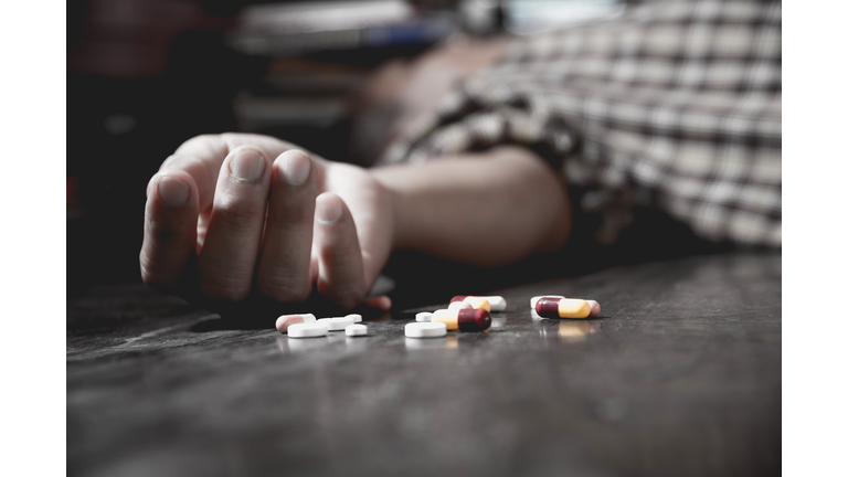 Close up of overdose pills and addict.