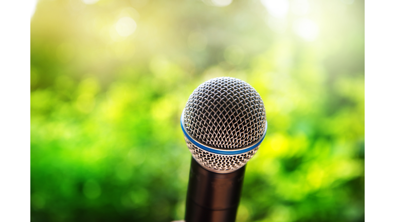 microphone for communication presentation or singing with green summer nature background