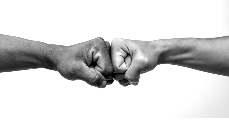 Man giving fist bump, monochrome, black and white image.