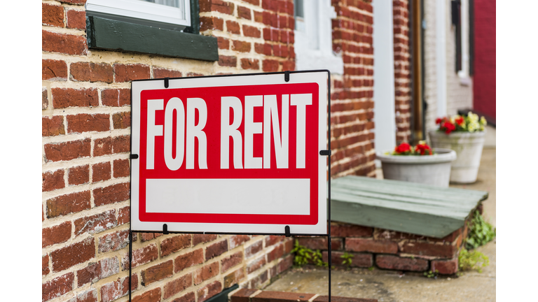 Red For Rent sign closeup against brick building