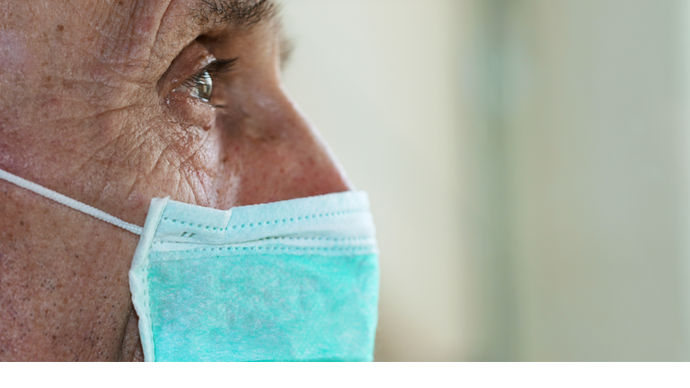 face of elderly man wearing medical facemask