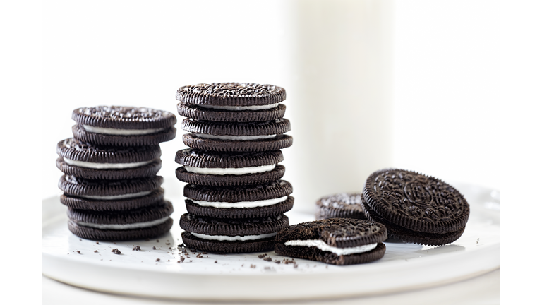 Oreo cookies stacked with milk on white background