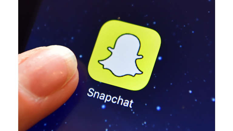 A finger next to the Snapchat app logo 