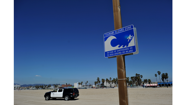 A police car passes one of many tsunami