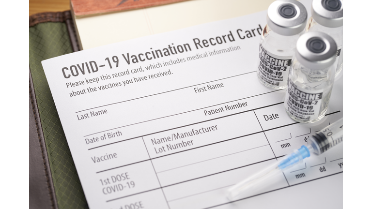 Covid-19 vaccination record card with vials and syringe.