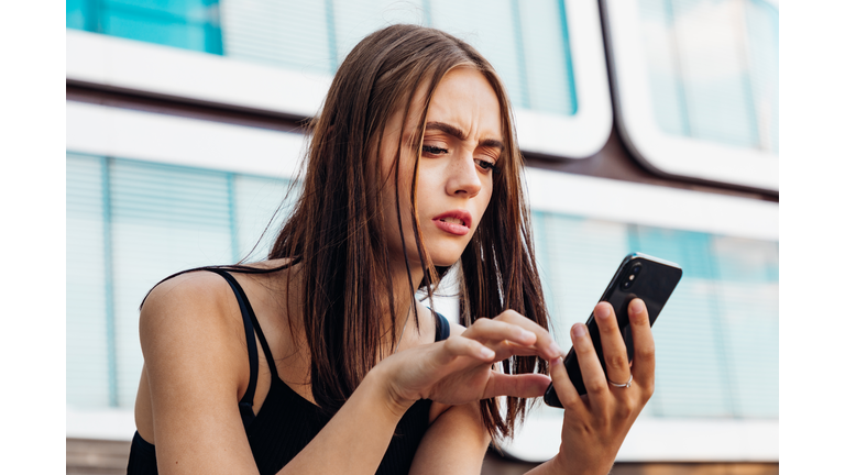 Worried Woman Checking Messages on Smart Phone