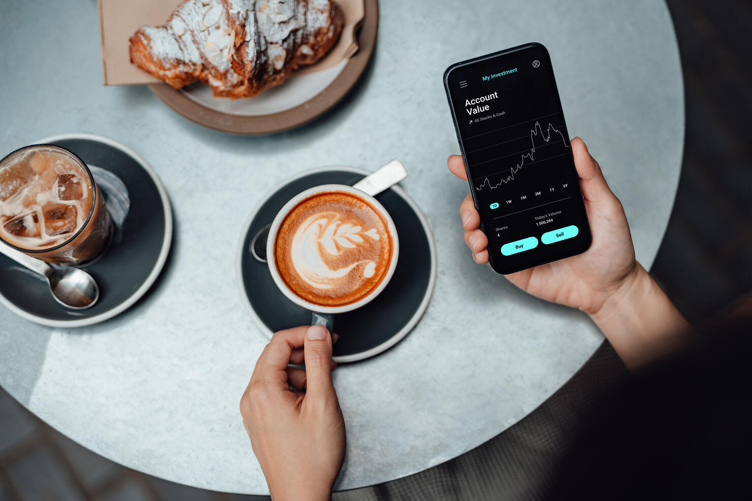 Young Woman Using Stock Trading App On Smart Phone At Cafe