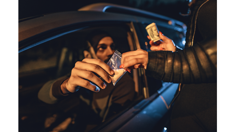 Drug dealer selling bag of heroin 