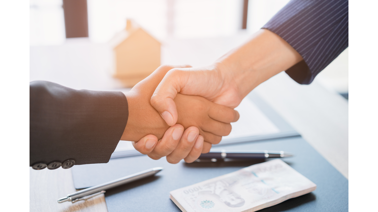 Real estate broker agent Shake hands after customer signing contract document for ownership realty purchase in the office, Business concept and  signing contract