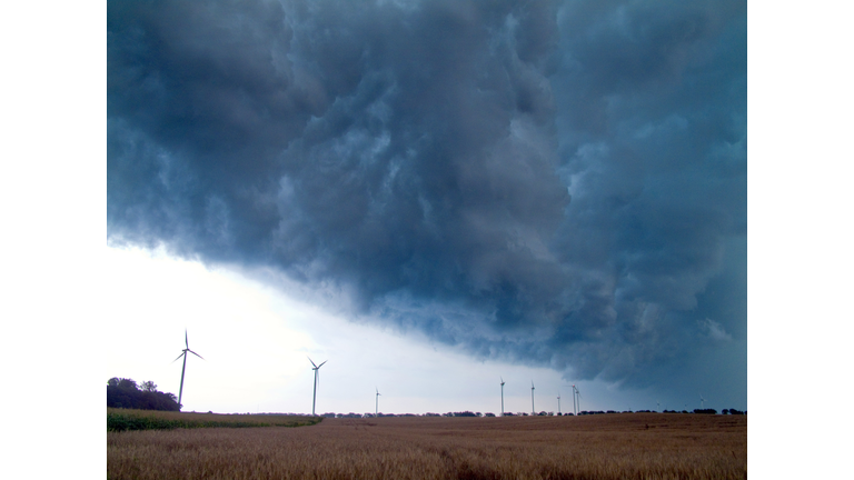 Storm clouds gather over a field with wi