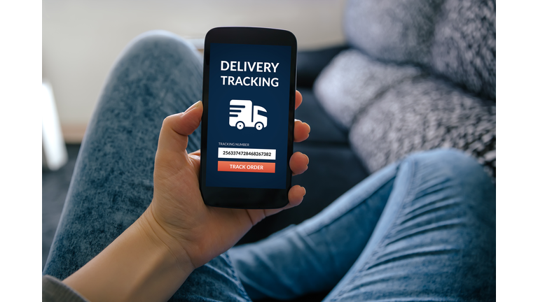 Girl holding smart phone with delivery tracking concept on screen