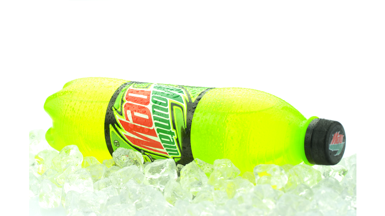 Bottle of Mountain Dew drink on ice isolated on white