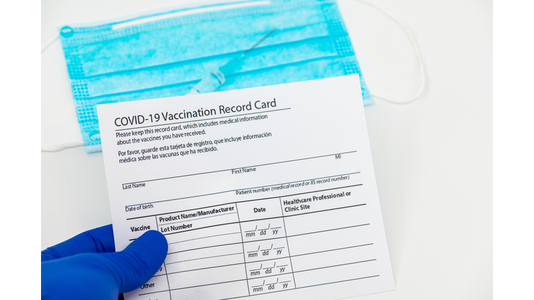 Covid-19 vaccination record card with vials and syringe.