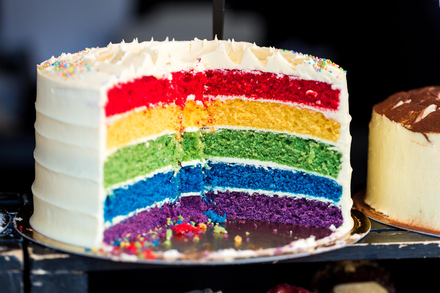 Close up Cross Section of Fresh Rainbow Layer Cake at Food Market