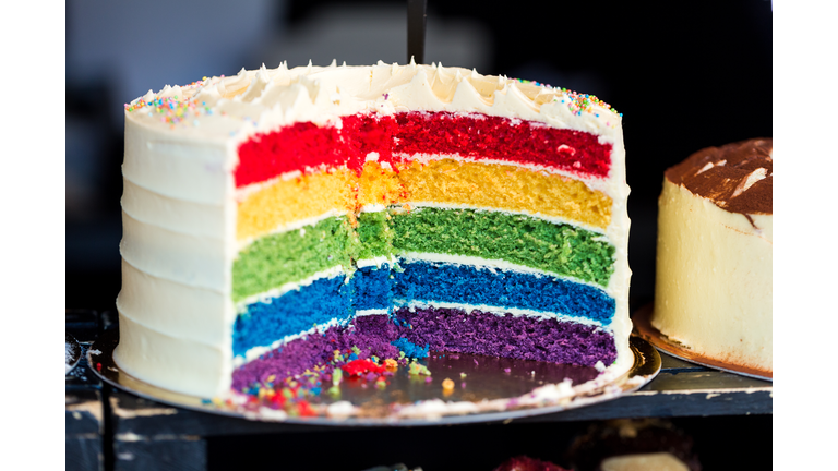Close up Cross Section of Fresh Rainbow Layer Cake at Food Market