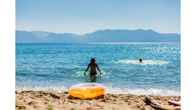 Swimming in a Mountain Lake with Blue Skies and an Orange Inflatable
