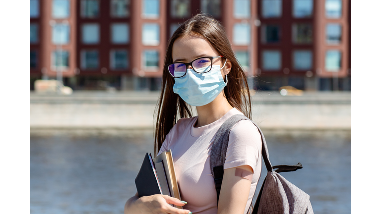 student teenage girl in medical protective mask with plaster on hand back to school after summer vacation, teenagers get the vaccine against covid-19