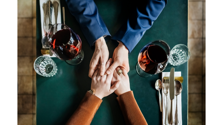Aerial View Of Couple Holding Hands At Restaurant Table