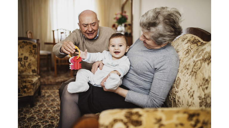 Grandparents playing with their baby grandson