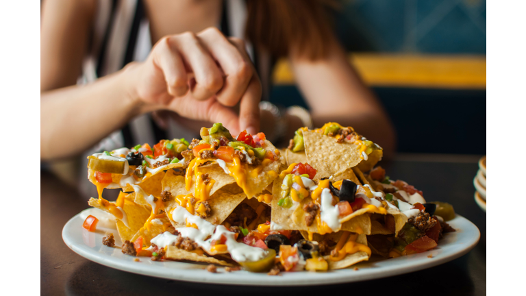 A young woman is eating a freshly made tacos