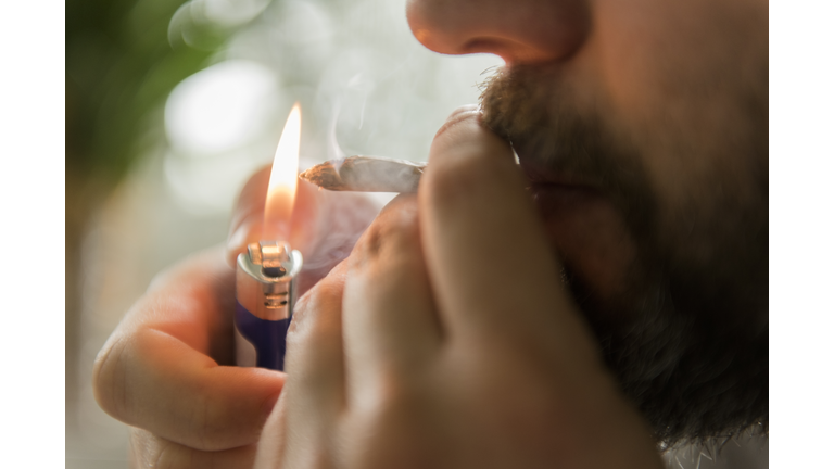 Man lighting marijuana joint